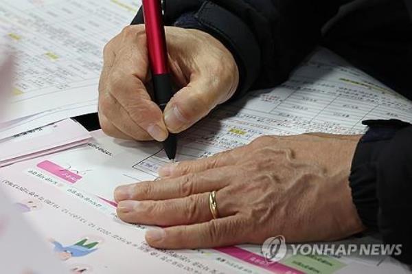 This Dec. 13, 2023, file photo shows a man filling out a job application form at a job fair in Seoul. (Yonhap)