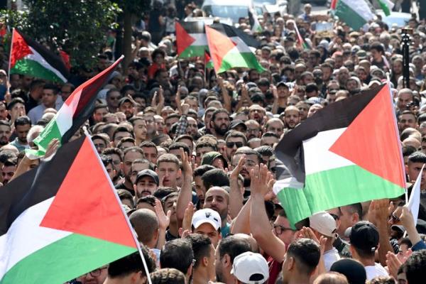 Palestinians wave the natio<em></em>nal flag during a demo<em></em>nstration in the city of Ramallah, in the occupied West Bank on October 18, 2023, protesting a strike on a Gaza hospital which killed hundreds a day earlier. Israel and Palestinians traded blame for the incident, which an 