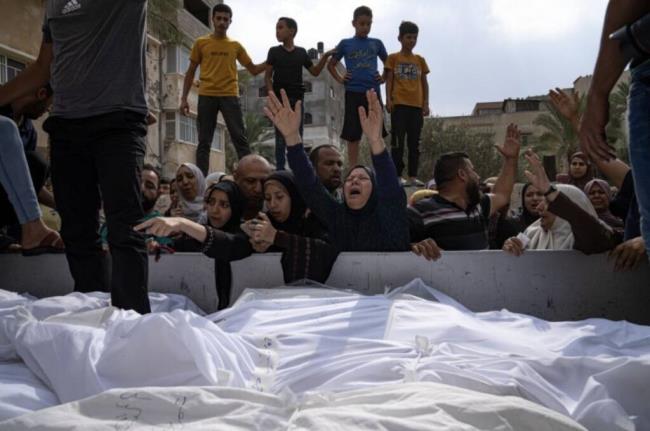 Relatives mourn people killed in an Israeli air strike in Gaza City on Monday, Oct. 9, 2023. Israel's military battled to drive Hamas fighters out of southern towns and seal its borders Mo<em></em>nday as it pounded the Gaza Strip. (AP Photo/Fatima Shbair)