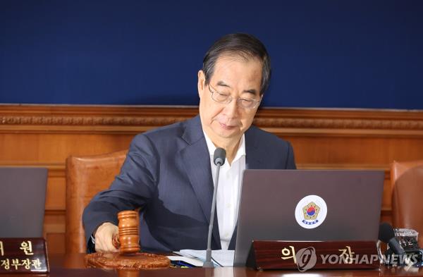 Prime Minister Han Duck-soo bangs the gavel during a Cabinet meeting at the government complex in Seoul on Aug. 6, 2024. (Yonhap)