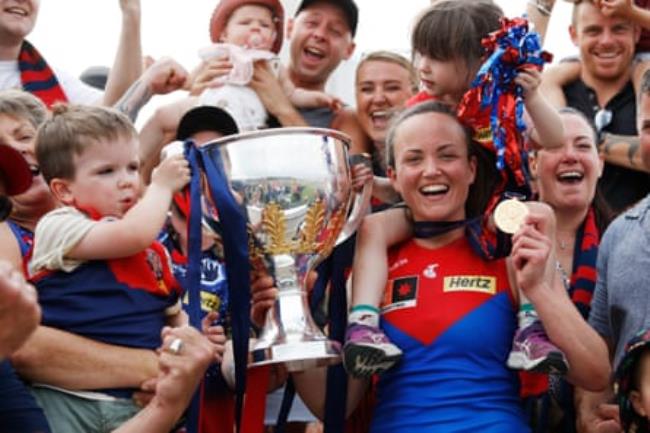 Daisy Pearce celebrates with family holding her medal and the AFLW trophy