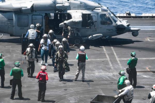 The Tutor's crew getting out of a helicopter on the Dwight D Eisenhower Carrier Strike Group after they were rescued by the US military