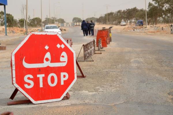 Tunisian security forces check vehicles near the Tunisian customs post at the Ras Jedir border crossing with Libya