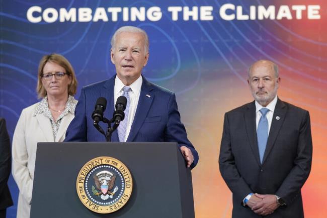 President Joe Biden speaks during an event to announce new measures aimed at helping communities deal with extreme weather, in the South Court Auditorium on the White House Campus, Thursday, July 27, 2023, in Washington. From left, Federal Emergency Management Agency administrator Deanne Criswell, Biden and Rick Spinrad, Administrator of the Natio<em></em>nal Oceanic and Atmospheric Administration. (AP Photo/Evan Vucci)