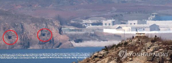 The gun ports of the coastal artillery (circled in red) on a North Korean island near the Northern Limit Line, a de facto maritime border, remain open, in this photo taken from South Korea's front-line island of Yeo<em></em>npyeong on Jan. 7, 2023. (Yonhap)